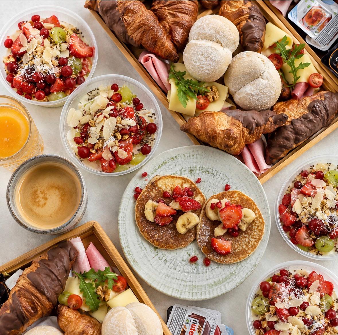 Ontbijt met koffie, fruit, yoghurt en koffiekoeken